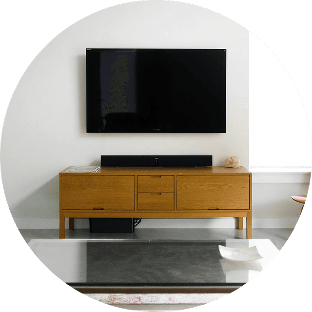 Salon minimaliste avec canapé gris, table d’appoint blanche et lampe.